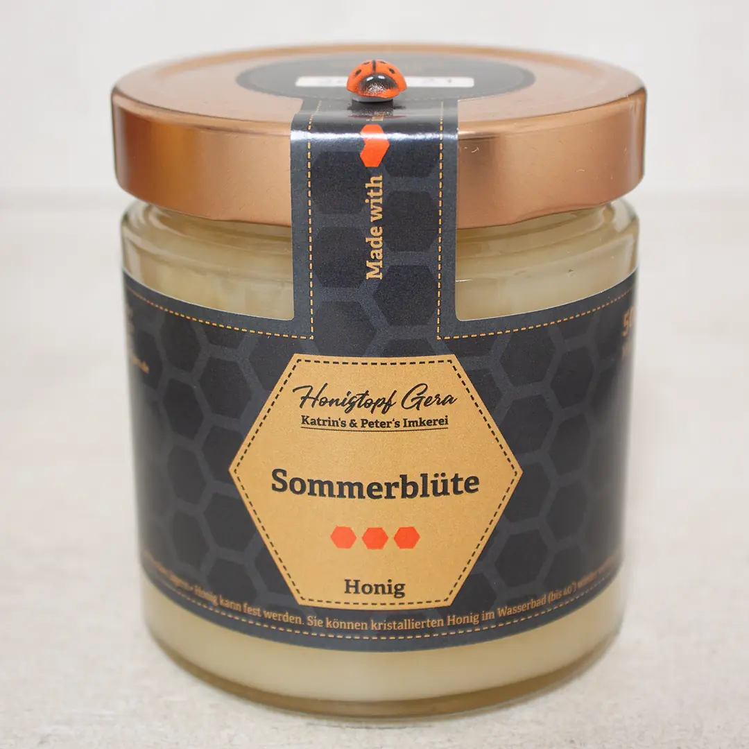 Goldgelber, cremiger und aromatischer Sommerblütenhonig im Glas